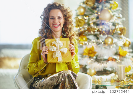 Smiling Woman with Green Blouse Holds Christmas Gift 132755444