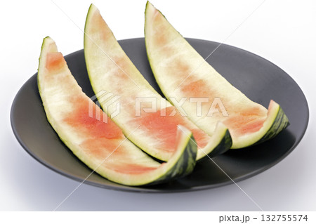 Watermelon rind leftover on a black plate with white background, used in Thai cooking 132755574