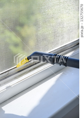 Cleaning window with steam cleaner indoors close-up. 132755670