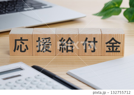 テーブルの上に応援給付金と書かれたブロック 132755712