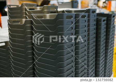 Stack of black plastic storage bins in warehouse setting Stack of black plastic storage bins in warehouse setting 132756082