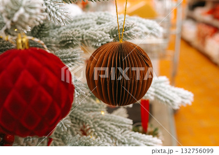 Festive christmas tree with red and brown ornaments and snowy branches Festive christmas tree with red and brown ornaments and snowy branches 132756099