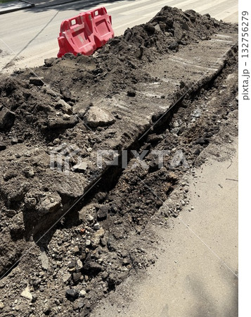Construction site trench with soil and orange barriers, concept of urban road infrastructure 132756279