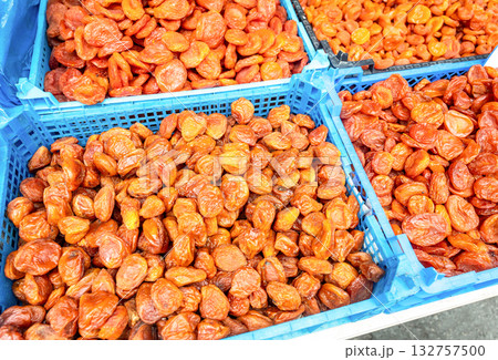Organic dried apricots in plastic crates at a farmers market. Large pile of dried apricots, dried fruits, healthy dessert, vegetarian food Organic dried apricots in plastic crates at a farmers market. Large pile of dried apricots, dried fruits, healthy dessert, vegetarian food 132757500