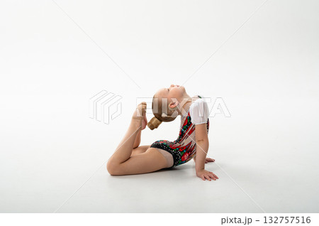 Little gymnast with cochlear implant stretching in backbend pose, copy space. Overcoming hearing challenges through art, flexibility, and emotional freedom in rhythmic gymnastics. Little gymnast with cochlear implant stretching in backbend pose, copy space. Overcoming hearing challenges through art, flexibility, and emotional freedom in rhythmic gymnastics. 132757516