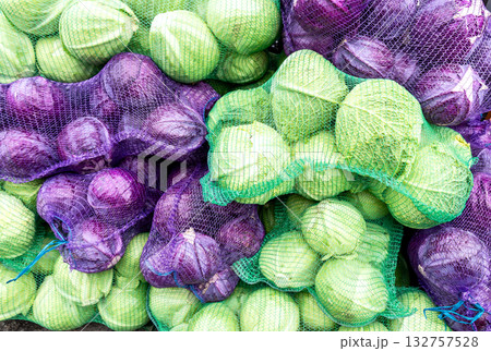 Fresh organic red and green cabbage in nets at a farmers market Fresh organic red and green cabbage in nets at a farmers market 132757528