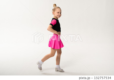 Little girl with hearing implant dancing in black and pink costume, copy space. Overcoming deafness with technology, creativity, and the expressive joy of inclusive childhood art. 132757534
