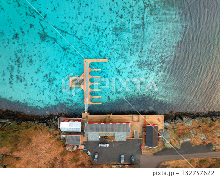Aerial view of wooden pier, azure water, houses on the sea coast 132757622