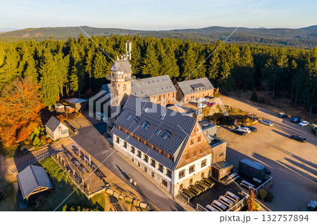 Kralovka Lookout Tower stands tall amidst the vibrant autumn foliage of the Jizera Mountains in Czechia. A clear sky highlights the natural beauty surrounding this historical site. 132757894