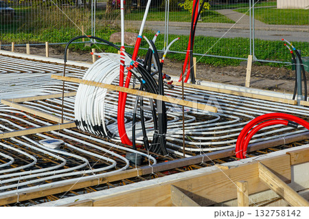 Underfloor heating system pipes and cables installed in concrete foundation construction Underfloor heating system pipes and cables installed in concrete foundation construction 132758142