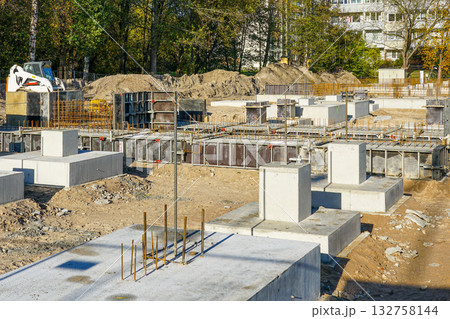 Apartment building concrete foundations with steel reinforcement under construction at urban site 132758144