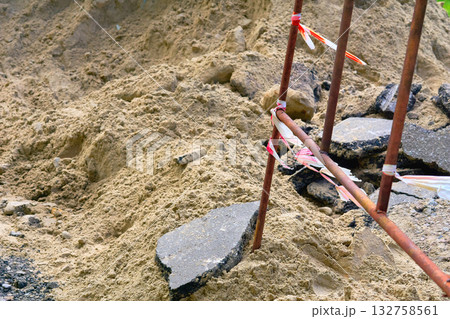 Road construction.Metal fencing of a dug pit when laying plumbing pipes Road construction.Metal fencing of a dug pit when laying plumbing pipes 132758561