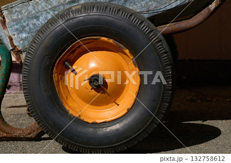 Old wheelbarrow rubber wheel with an orange rim Old wheelbarrow rubber wheel with an orange rim 132758612