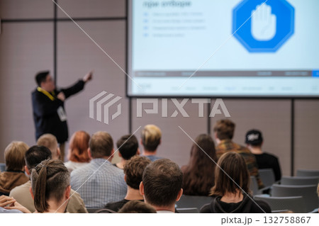 Presenter speaks at conference to audience with slide show and security icon on screen 132758867