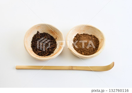 Hojicha Tea and Powder. Ceramic bowls with tea leaves and powder on a white surface Hojicha Tea and Powder. Ceramic bowls with tea leaves and powder on a white surface 132760116