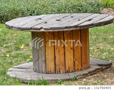 Old wooden cable reel for construction site on the grass. Old wooden cable reel for construction site on the grass. 132760405