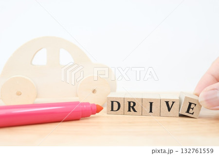 木製の車とDRIVE文字ブロック。ドライブやカーライフをイメージした作品。 132761559