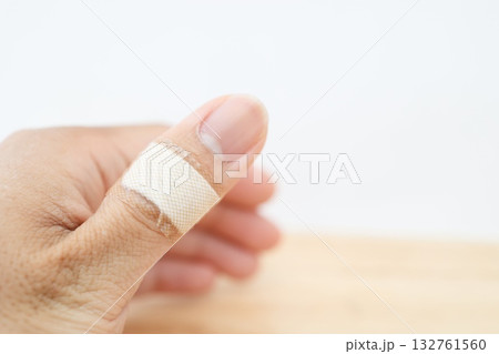 親指の関節に絆創膏を貼った手元。 132761560