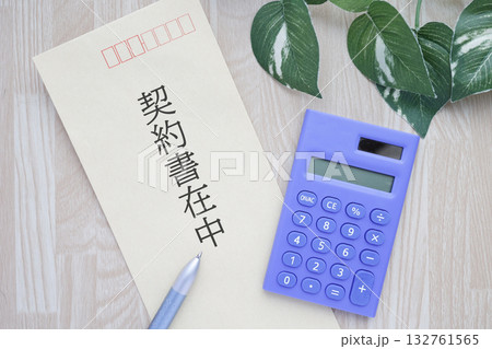 契約書在中の封筒と電卓のイメージ。ビジネス手続きや書類管理の概念。 132761565