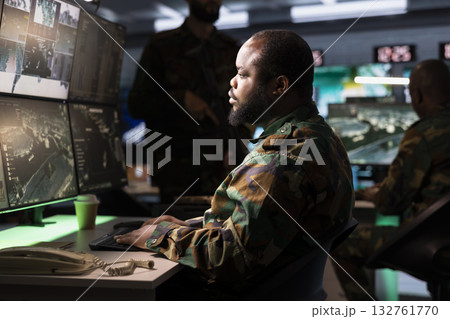 Counterterrorism division officer using target acquisition tech to detect enemy location. Defense security agent in base of operations using satellite equipment to track threats Counterterrorism division officer using target acquisition tech to detect enemy location. Defense security agent in base of operations using satellite equipment to track threats 132761770