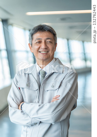 腕組みをする作業着の男性 132762443