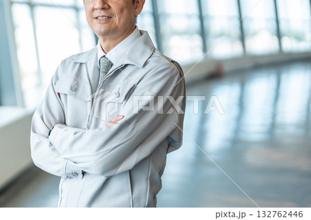 腕組みをする作業着の男性 132762446