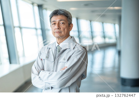 腕組みをする作業着の男性 132762447