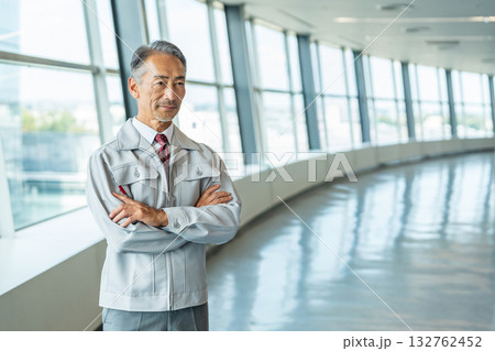 オフィスのロビーに立つ作業服を着たシニア男性 132762452