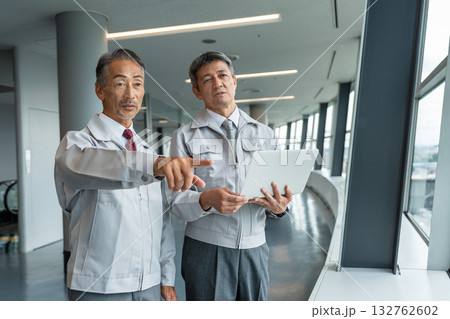 現場で図面を見る作業服を着た男性と現場監督 現場で図面を見る作業服を着た男性と現場監督 132762602