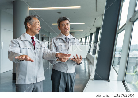 現場でパソコンを操作する作業服のシニア男性 現場でパソコンを操作する作業服のシニア男性 132762604