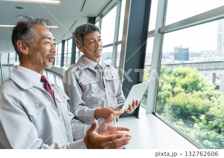 現場でパソコンを操作する作業服の男性 132762606