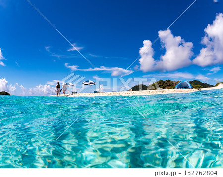 白砂のビーチの半水面撮影。美しいサンゴ礁と熱帯魚の群れ。 嘉比島沖縄県 島尻郡慶良間諸島座間味島 132762804
