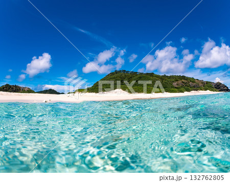 白砂のビーチの半水面撮影。美しいサンゴ礁と熱帯魚の群れ。 嘉比島沖縄県 島尻郡慶良間諸島座間味島 132762805