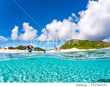 白砂のビーチの半水面撮影。美しいサンゴ礁と熱帯魚の群れ。 嘉比島沖縄県 島尻郡慶良間諸島座間味島 132762831