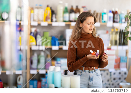 Young woman choosing nail polish in retail store 132763719
