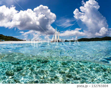 沖縄のサバニと白砂ビーチの半水面撮影。美しいサンゴ礁と熱帯魚の群れ。 嘉比島沖縄県 島尻郡慶良間諸島 132763804