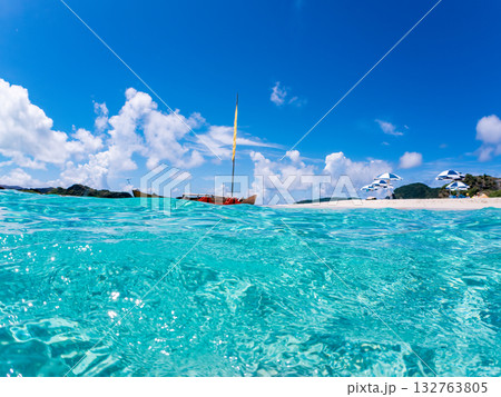 沖縄のサバニと白砂ビーチの半水面撮影。美しいサンゴ礁と熱帯魚の群れ。 嘉比島沖縄県 島尻郡慶良間諸島 沖縄のサバニと白砂ビーチの半水面撮影。美しいサンゴ礁と熱帯魚の群れ。 嘉比島沖縄県 島尻郡慶良間諸島 132763805