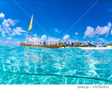 沖縄のサバニと白砂ビーチの半水面撮影。美しいサンゴ礁と熱帯魚の群れ。 嘉比島沖縄県 島尻郡慶良間諸島 132763812