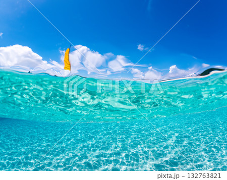 沖縄のサバニと白砂ビーチの半水面撮影。美しいサンゴ礁と熱帯魚の群れ。 嘉比島沖縄県 島尻郡慶良間諸島 132763821