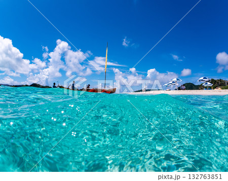 沖縄のサバニと白砂ビーチの半水面撮影。美しいサンゴ礁と熱帯魚の群れ。 嘉比島沖縄県 島尻郡慶良間諸島 132763851