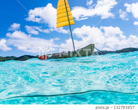 沖縄のサバニと白砂ビーチの半水面撮影。美しいサンゴ礁と熱帯魚の群れ。 嘉比島沖縄県 島尻郡慶良間諸島 132763857