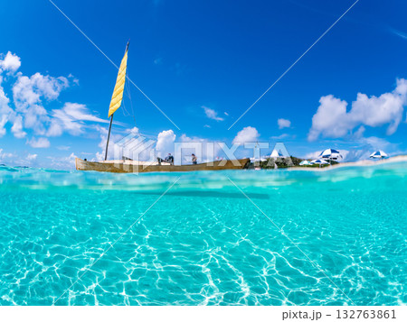 沖縄のサバニと白砂ビーチの半水面撮影。美しいサンゴ礁と熱帯魚の群れ。 嘉比島沖縄県 島尻郡慶良間諸島 132763861