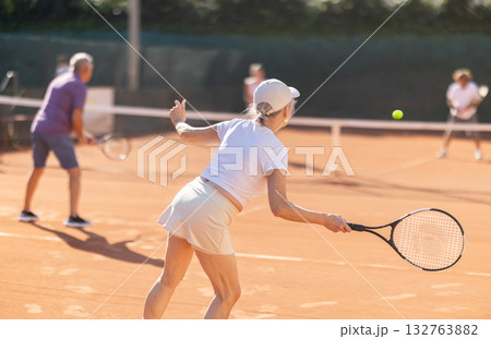 Elderly couple playing tennis together on summer court 132763882