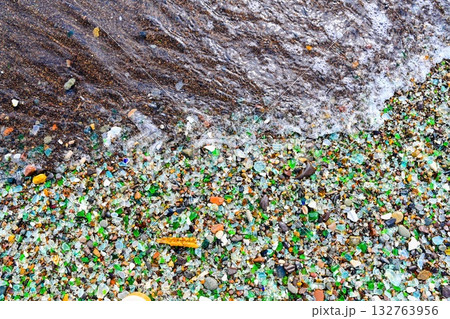 Colorful sea glass and ceramic fragments on the shore of Glass Bay, Vladivostok, Russia. Smooth pieces sparkle in the waves of the Japanese Sea. 132763956
