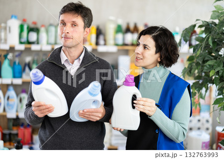 Woman seller offers detergent to adult man buyer 132763993