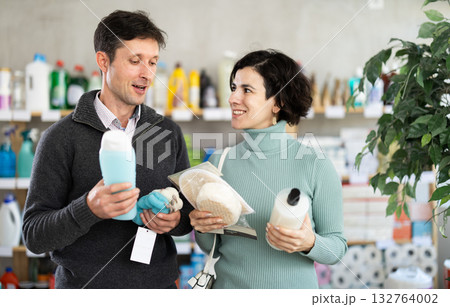 Married couple chooses shampoo, body wash and loofah in household goods department of supermarket Married couple chooses shampoo, body wash and loofah in household goods department of supermarket 132764002