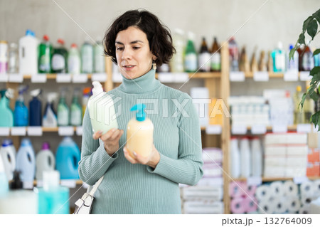 Middle-aged woman choosing liquid hand soap at department store 132764009