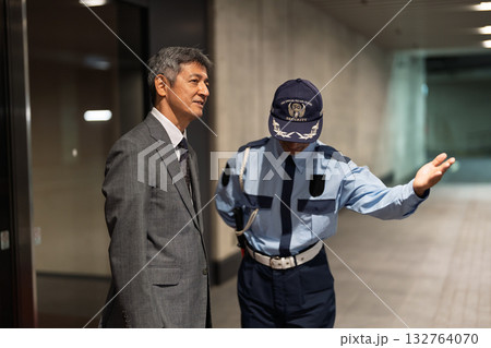 ビルの前で話す警備員とビジネスマン 132764070