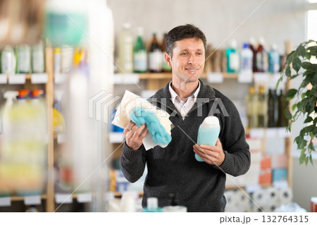 Man in a jumper holding washcloths with shower gel 132764315