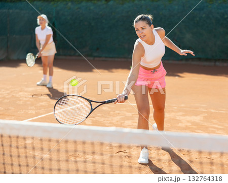 Young woman playing tennis with older woman Young woman playing tennis with older woman 132764318